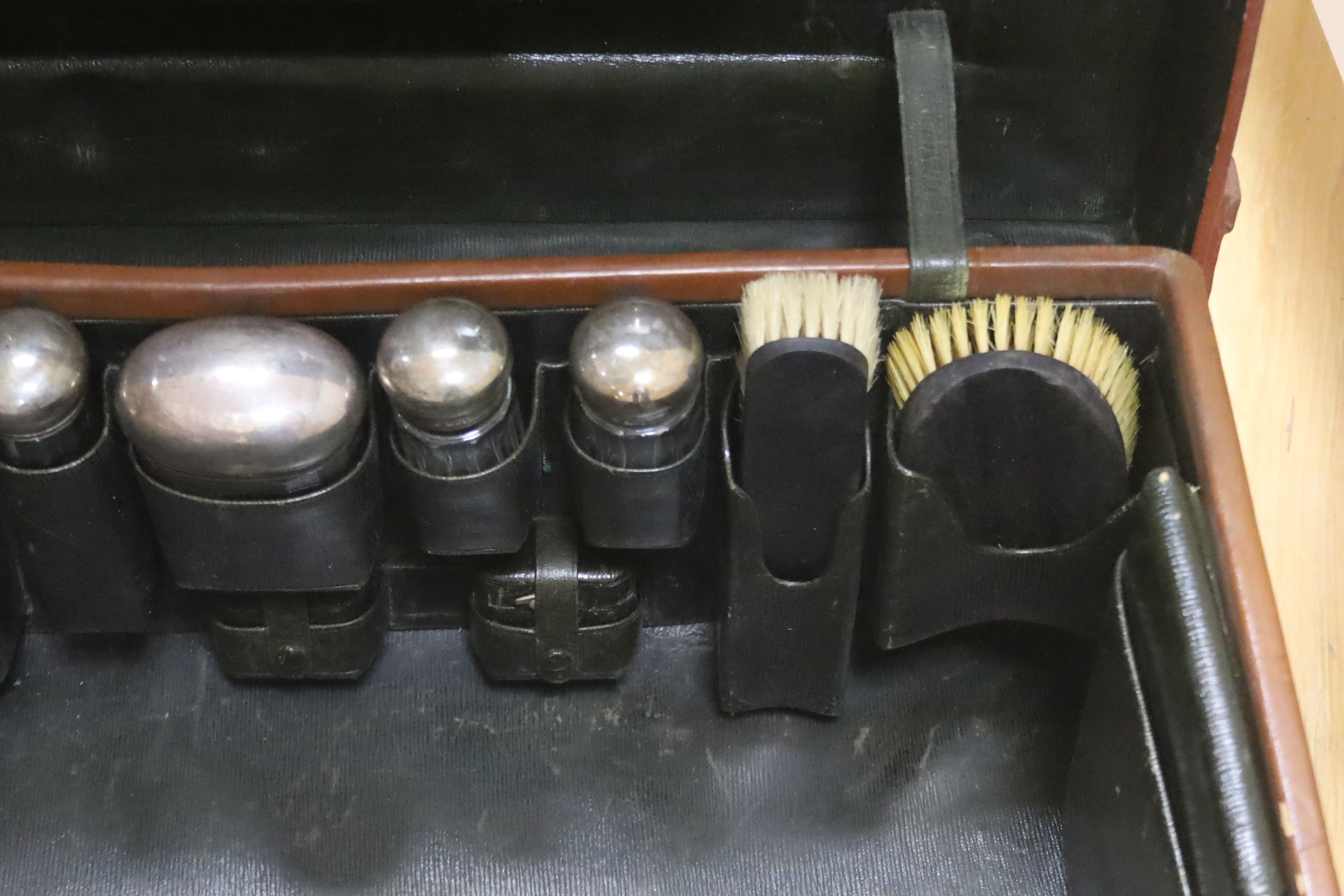 A gentleman's brown leather cased silver travelling vanity set, with silver lidded bottles interior, initialled HS